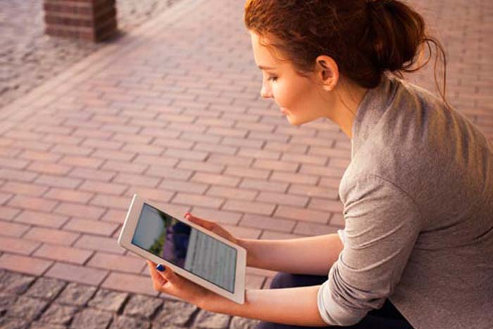 Woman Looking at DIY Books on Her Tablet.